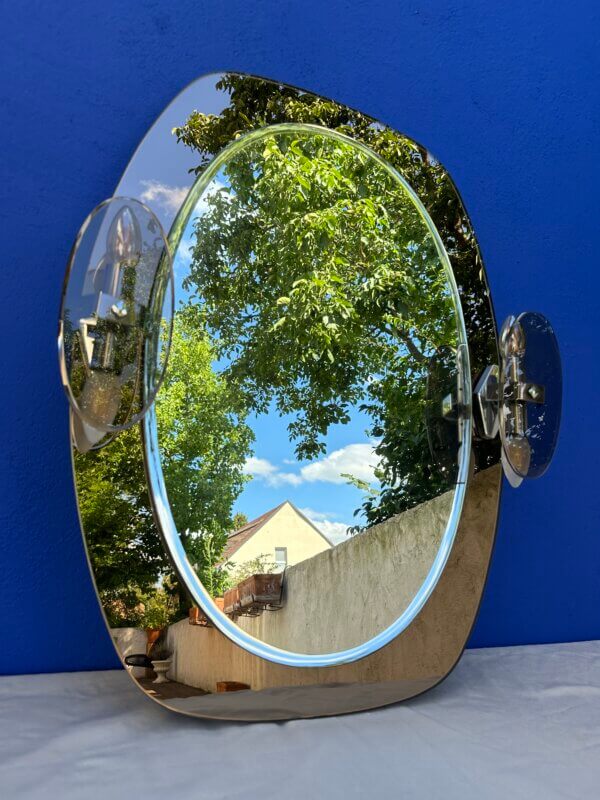 Années 70. Très joli miroir sur un cadre en verre fumé avec ses appliques, en très bon état général. Belle pièce pour une salle de bain, une entrée, un couloir … 80 cm de haut et 63 cm de large. Électricité ok. Ampoules E14 (vendu sans ampoules)