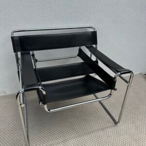 Fauteuil en cuir noir avec structure en métal chromé, dans le style iconique du modèle Wassily de Marcel Breuer.