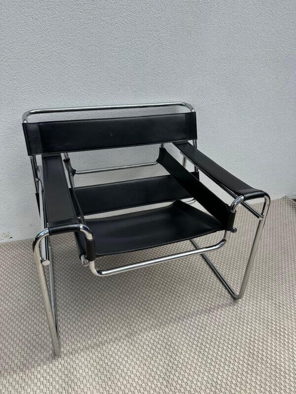Fauteuil en cuir noir avec structure en métal chromé, dans le style iconique du modèle Wassily de Marcel Breuer.