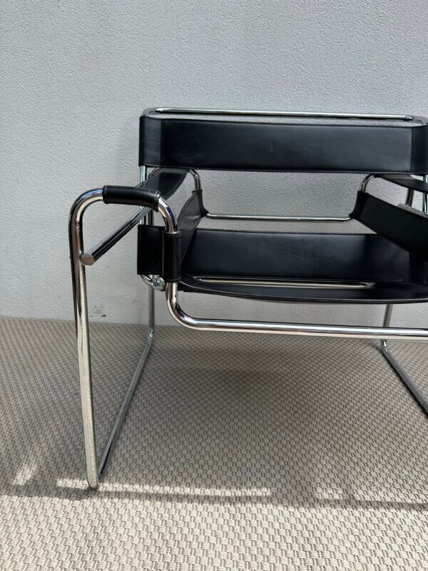 Fauteuil en cuir noir avec structure en métal chromé, dans le style iconique du modèle Wassily de Marcel Breuer.